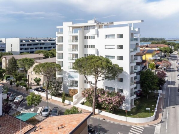 A modern multi-story building with balconies, a rooftop pool, and a sign reading "ZERO ZERO". - Zero5.Zero5 Residence by Interhome (Lignano Sabbiadoro)