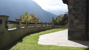 A curved pathway leading to a stone building with a stone wall and metal railings. - Luxury flat with sauna in the French Alps (Champagny en Vanoise)