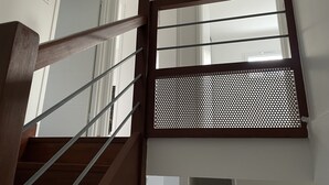 A wooden staircase with a metal handrail leading to a room with a window and a door. - House 87 M2 in closed and secured residence 500m from the beach (Capbreton)