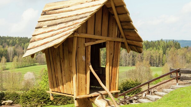 Une structure en bois dotée d’un toit en pente et d’un escalier menant à son sommet.