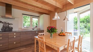 Une cuisine moderne avec des meubles en bois, un îlot central et des luminaires suspendus.