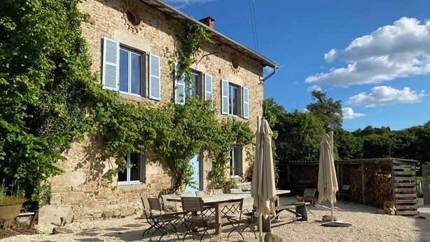A stone building with blue shutters, a gravel patio, outdoor furniture, and a pergola. - Holiday Home in Saint-Léonard with Pool (Saint Léonard de Noblat)