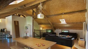 A rustic interior with a wooden table, benches, a sofa, and a kitchen area. - Holiday Home in Saint-Léonard with Pool (Saint Léonard de Noblat)