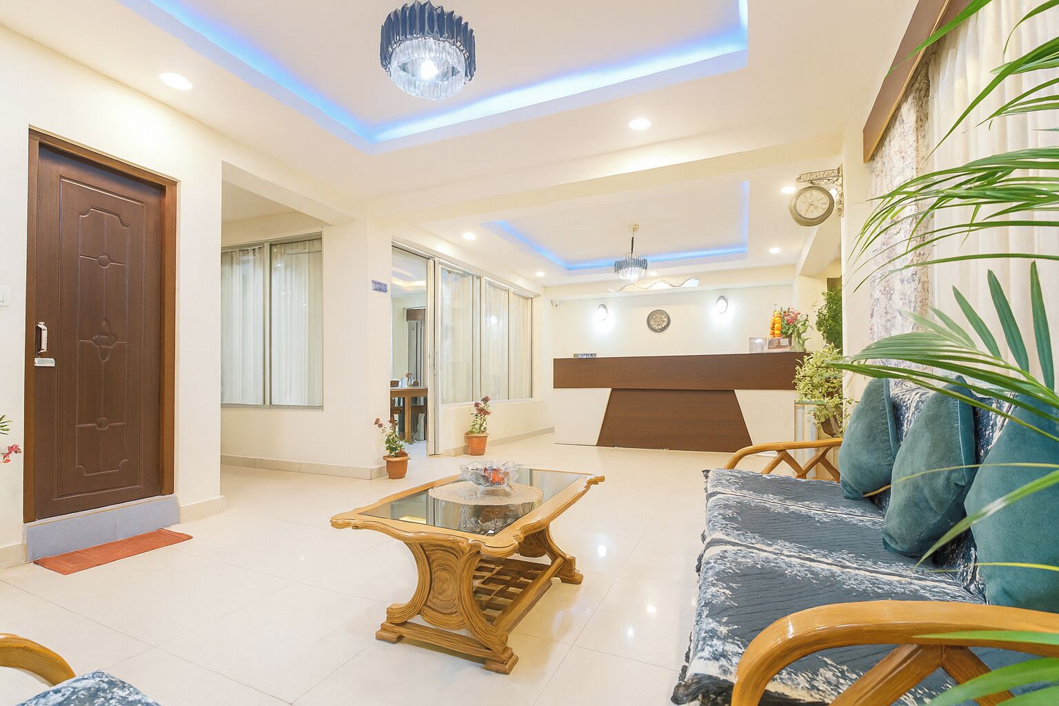 Uma sala de estar moderna com um sofá, uma mesa de centro, uma cadeira de madeira e uma mesa de recepção.