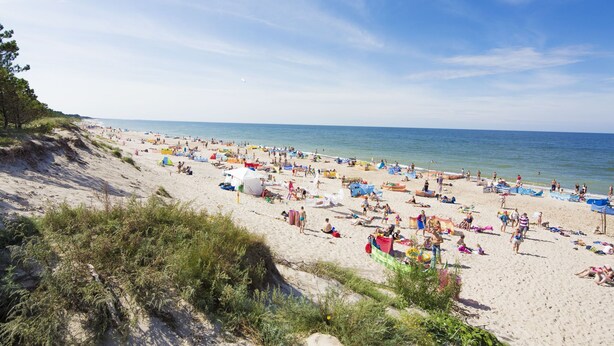 A crowded beach with people sunbathing and swimming. - Holiday home located near the sea; ideal for relaxing with family. (Mielno)