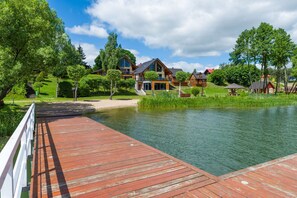 Un muelle de madera que lleva a un lago con casas al fondo.