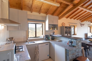 A modern kitchen with granite countertops, a dishwasher, and a large window offering a view of the countryside. - Holiday home with private pool (Valença-de-Douro)