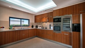 A modern kitchen with wooden cabinets, stainless steel appliances, and a skylight.