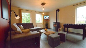 A cozy living room with a sofa, coffee table, and a foosball table. - Villa in Berismenil near Forest (Berismenil (La Roche-en-Ardenne) Ardennes)