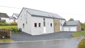 A modern two-story house with a garage, a stone extension, and a well-maintained garden. - Villa in Berismenil near Forest (Berismenil (La Roche-en-Ardenne) Ardennes)