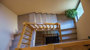 A wooden staircase with a handrail, leading to a landing with a potted plant. - Lovely Apartment  in Biograd na Moru with Balcony (Biograd na Moru)