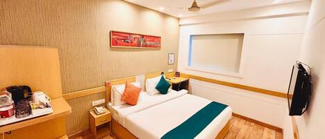 A hotel room with a bed, bedside table, nightstand, and a window.