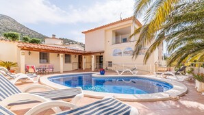 A pool area with lounge chairs, a small pool, and a building with a tiled roof and a balcony. - Modern Villa near Beaches (Roses)