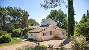 Een huis met pannendak, een klein portaaltje en een oprit met grind.
