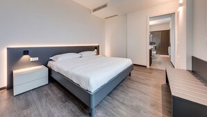 A modern bedroom with a bed, bedside tables, and a bench.