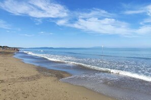 Une plage avec un ciel dégagé et une mer calme.