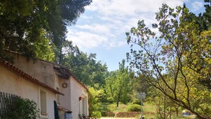 Un sendero de grava que lleva a una construcción rústica con techo de tejas y una puerta.