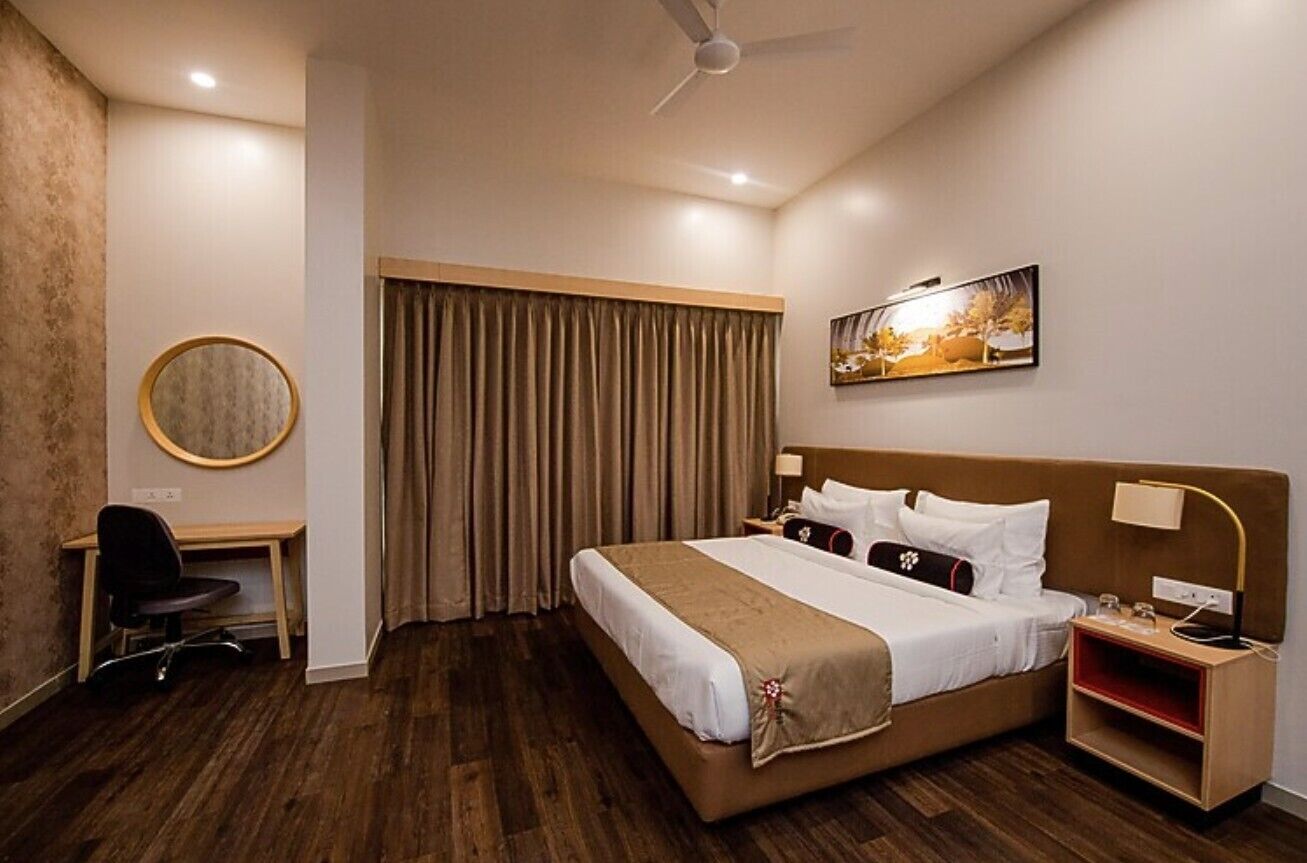 Ein Hotelzimmer mit Bett, Schreibtisch, Stuhl und einem Bild an der Wand.