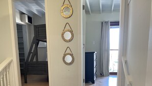 A staircase with three wall-mounted mirrors and a view into a room with a window and curtains. - Hidden Treasure - located ON the boardwalk! (Christiansted)