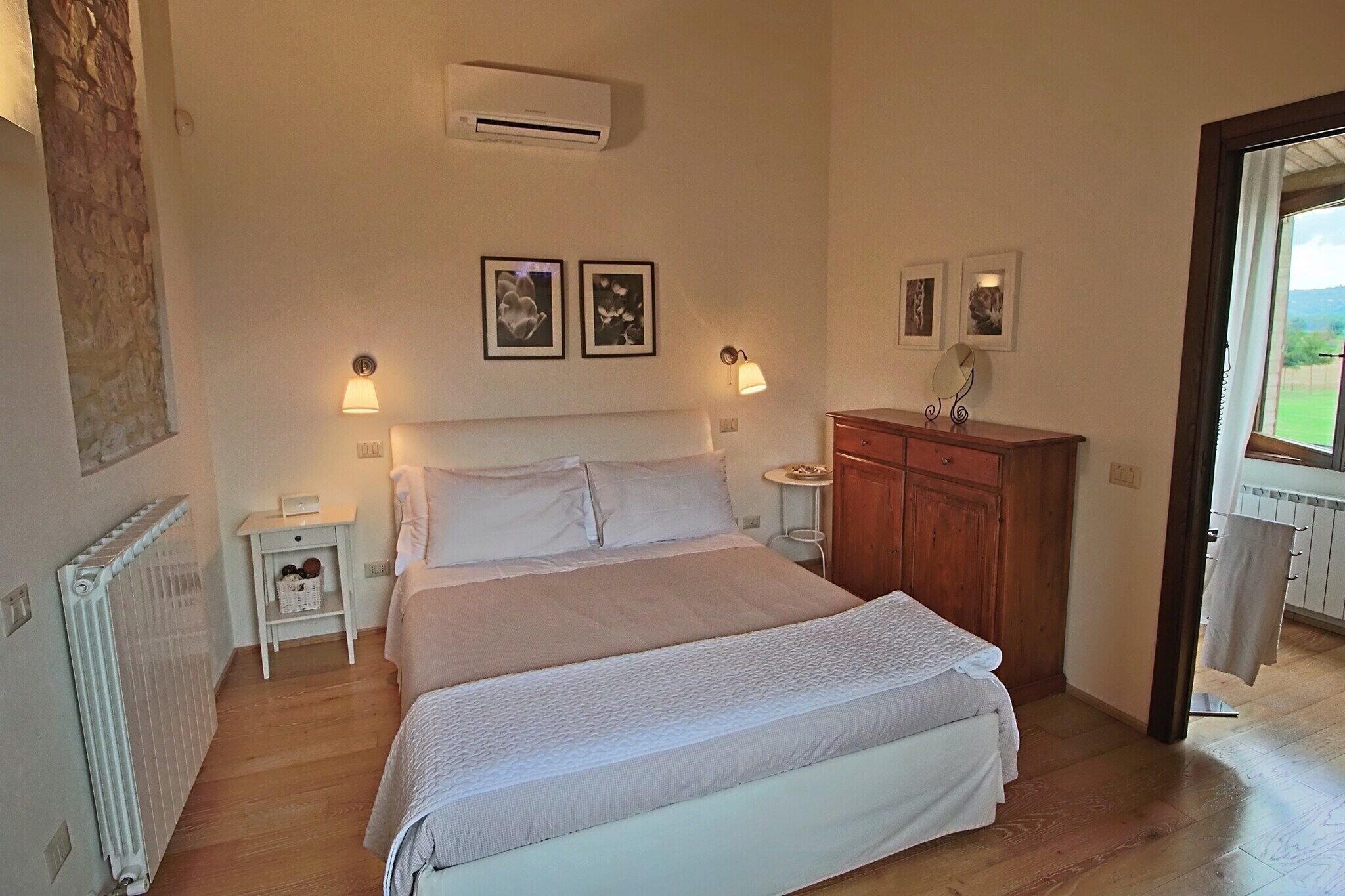 A bedroom with a large bed, bedside tables, a wooden dresser, and a radiator.