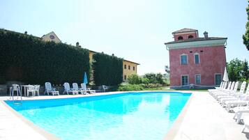 A swimming pool with lounge chairs and a building in the background.