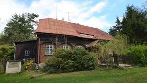A two-story house with a red roof, surrounded by a wooden fence and a small garden. - Family Chalet with Garden (Krásná Lípa)