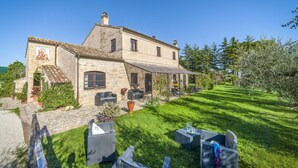 A stone building with a patio area, outdoor seating, and a garden.