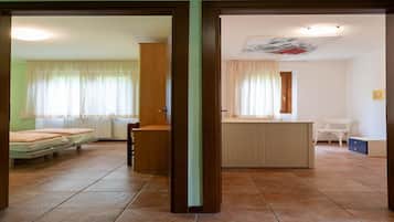 A room with a bed, a wooden cabinet, a desk, and a chair.