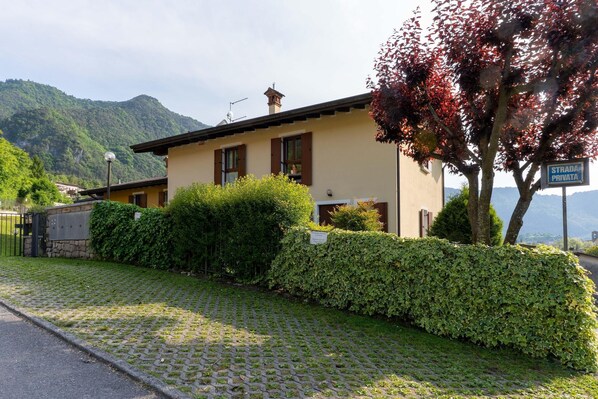 A building with a paved driveway, a hedge, and a sign indicating a private street. - Holiday Home in Idro near Scenic Hills (Idro (bs))