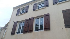A building with multiple windows, some with shutters, and a visible number '8' on the facade. - Studio Centre Ville et Bord de mer (Les Sables-d'Olonne)