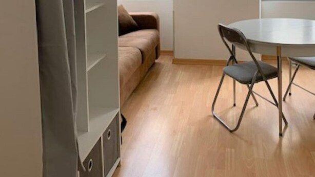 A room with a sofa, a dining table with chairs, and a wardrobe. - Studio Centre Ville et Bord de mer (Les Sables-d'Olonne)