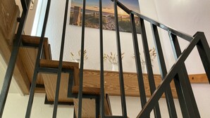 A staircase with wooden steps and black metal railings. - Maisonette apartment near the beach - beach chair included! (Dahme)