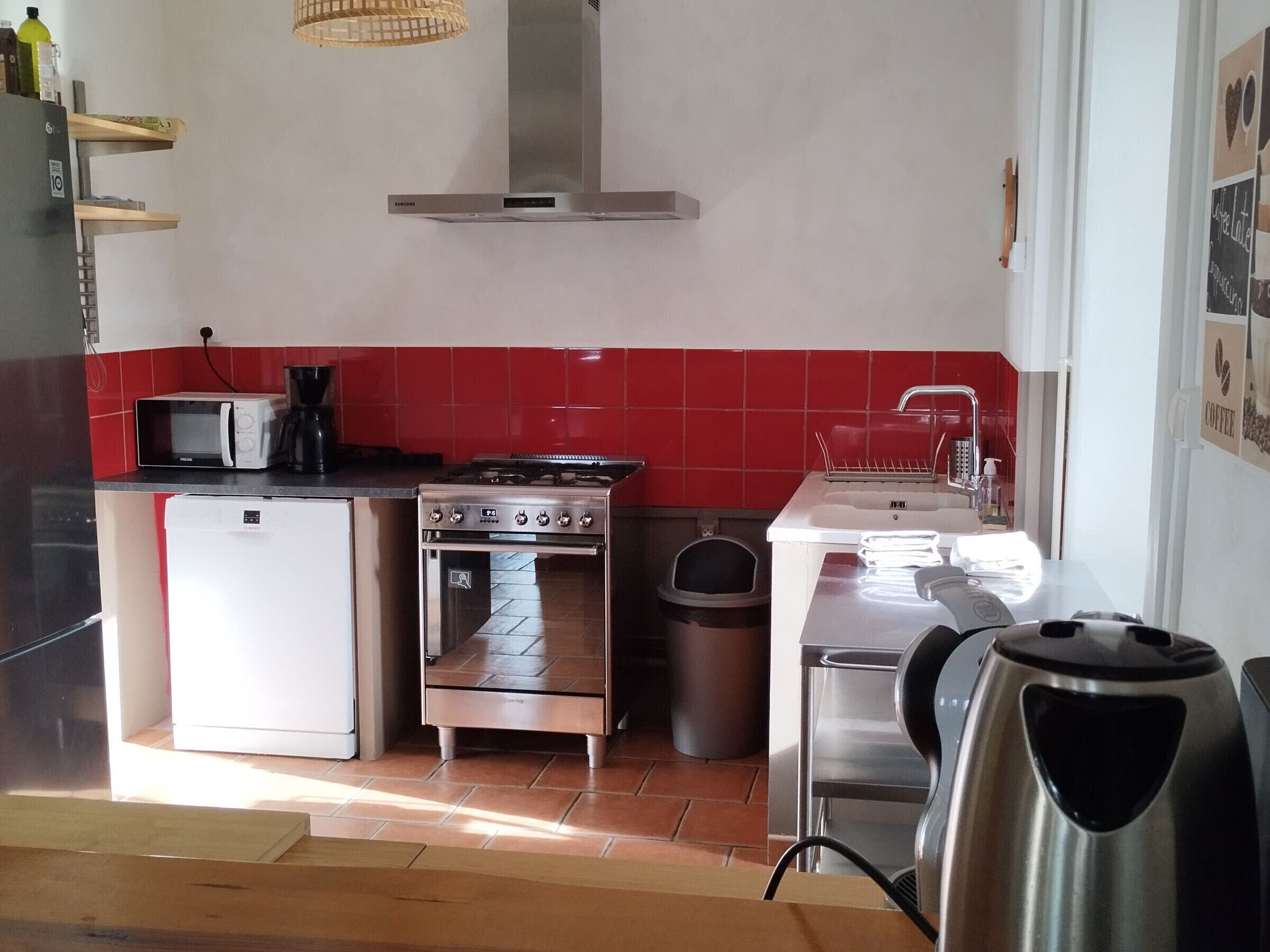 Une cuisine compacte équipée d’un four à micro-ondes, d’une cuisinière, d’un four et d’un évier.