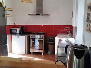 Eine kompakte Küche mit Mikrowelle, Herd, Backofen und Spüle.