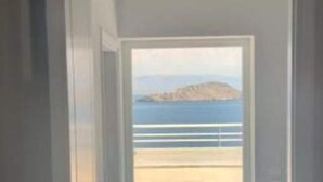 A hallway leading to a balcony with a view of the sea and a distant landmass. - Charming 4-bed Villa in Pefkali (Corinth)