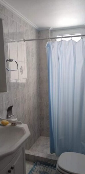 A bathroom with a shower, toilet, and sink. - Charming 4-bed Villa in Pefkali (Corinth)