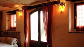 Una stanza con un letto, una porta e due finestre con tende.