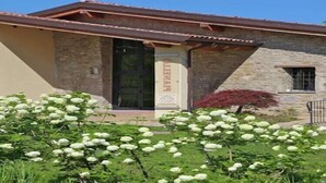 Un edificio in pietra con tetto in tegole e una porta con su scritto 'BIAUETT'.