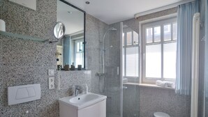 A modern bathroom with a glass-enclosed shower, a white sink, and a vanity. - Comfort plus apartment with 1 bedroom and balcony on the upper floor (Ostseebad Binz)