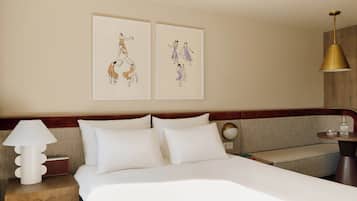 Habitación de hotel con una cama, una mesita de noche con lámpara, una mesilla auxiliar y dos cuadros enmarcados en la pared.