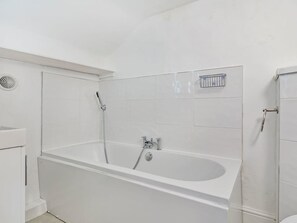 A modern bathroom with a freestanding bathtub, a showerhead, and a small shelf. - Lovely Period Villa Sleeps 8 Resting in Torquay (Torquay)