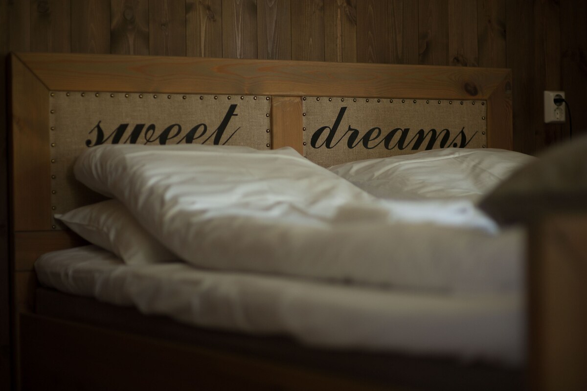 A bed with a headboard that has the words 'sweet dreams' on it.