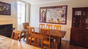 Un coin repas avec une table et des chaises en bois, une carte accrochée au mur et un buffet.