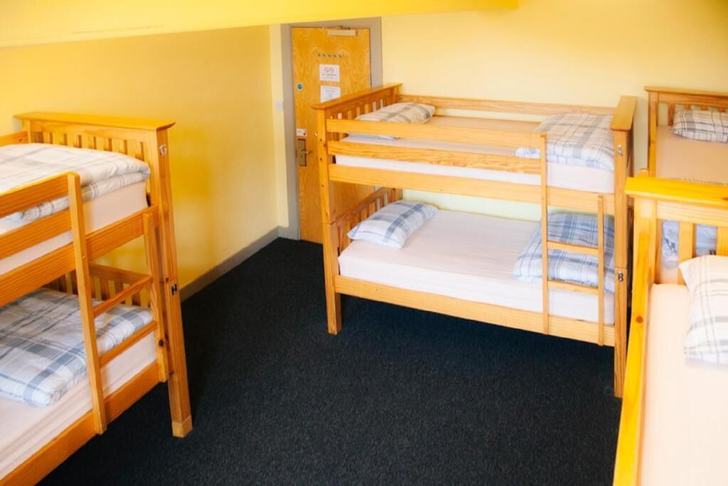 Una habitación con literas, una puerta y piso alfombrado.