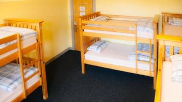Una habitación con literas, una puerta y piso alfombrado.