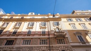 A multi-story building with classical architecture, featuring arched windows and balconies. - Dolcevita Terrace (Roma)