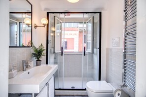 Kombination af bruser/badekar, hårtørrer, bidet, håndklæder