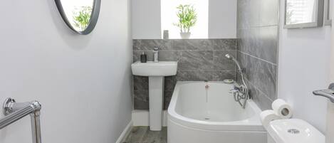 Une salle de bain moderne avec une baignoire, des toilettes et un lavabo.