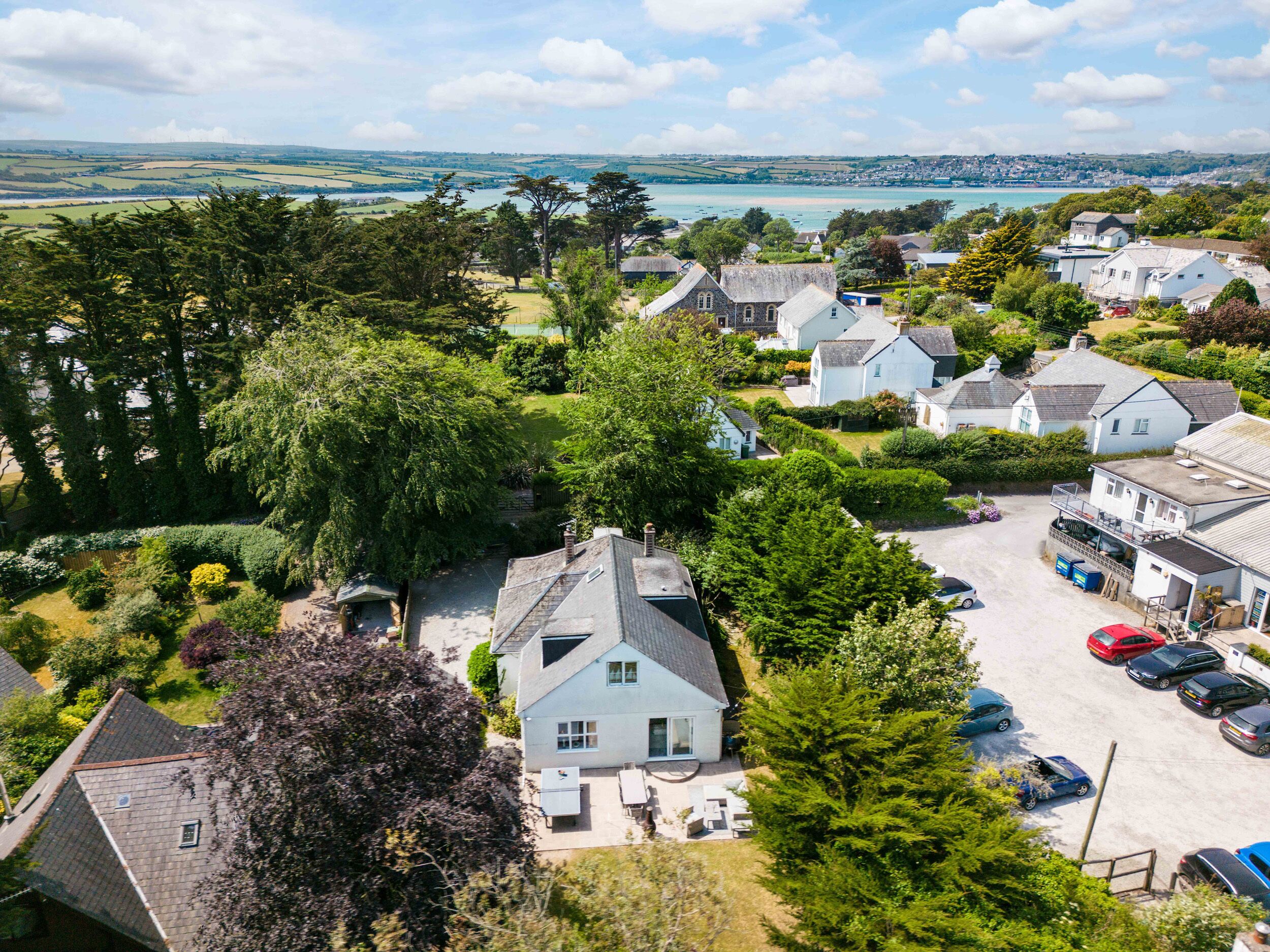 A coastal village with houses, a parking area, and a view of the sea.