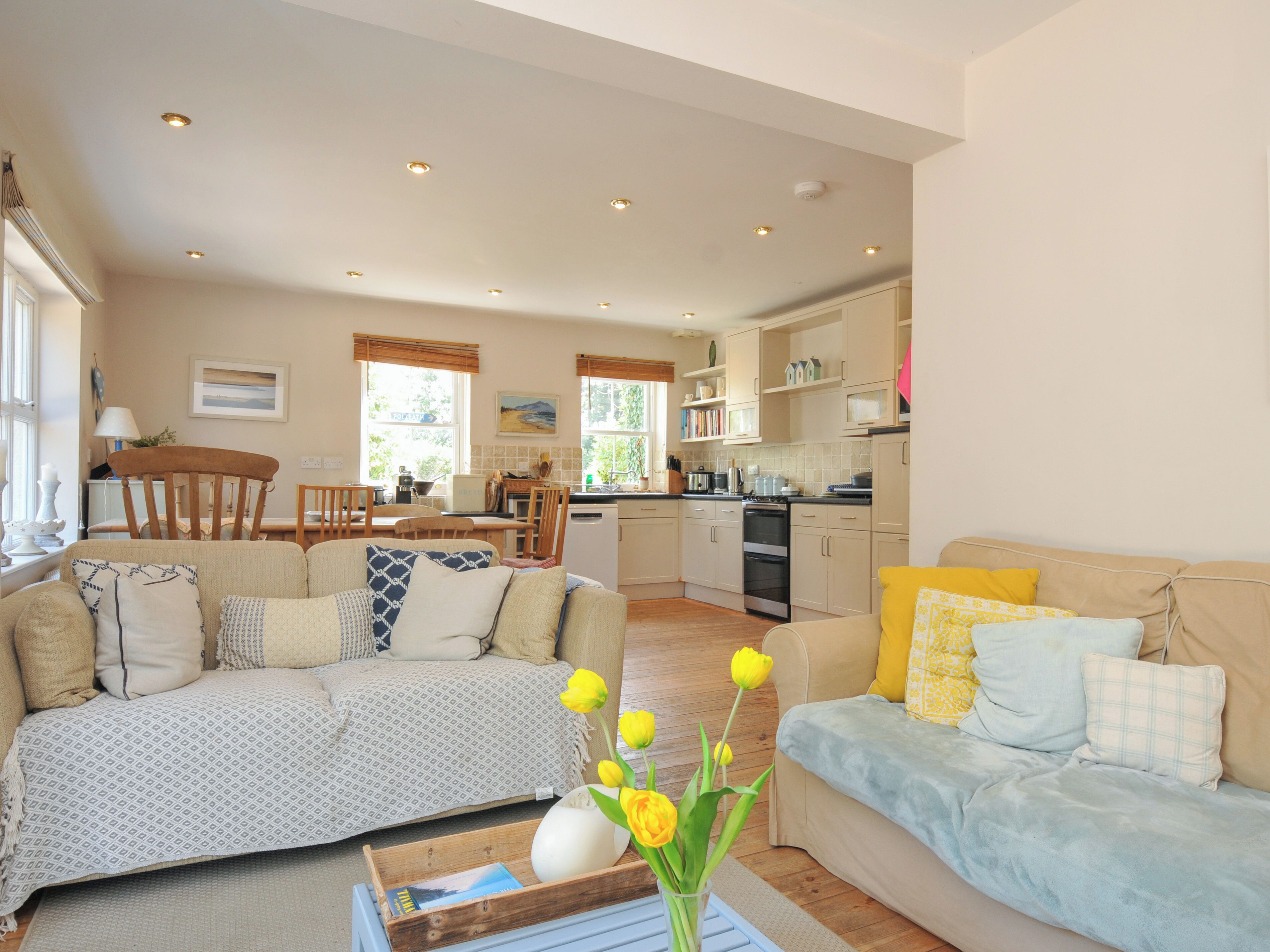 A living room with a sofa and a dining area with a table and chairs.